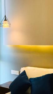 グルガオンにあるPantao Luxe Studio-AIPL Joy Squareのベッドルーム1室(黄色い壁のベッド1台付)