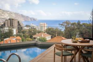 a table and chairs on a balcony with a view at Green Boat by Madeira Best Apartments in Funchal