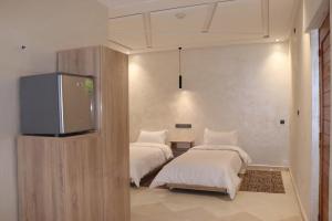 米德勒特VANA hôtel的配有平面电视的客房内的两张床