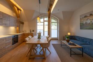 a living room with a table and a blue couch at Reethus 22 Loft 7 in Timmendorfer Strand