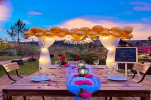 a wooden table topped with glasses and a balloonedescription at BonBon Villa & Coffee in Bảo Lâm