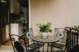 d'une table avec des chaises et d'un vase avec une plante. dans l'établissement La Serra Apartment with balcony, à Vérone 2 autres photos