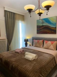 a bedroom with a large bed with two towels on it at top8 view in Tríkala