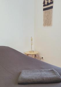 a bed with a brown blanket and a table at L'Oasis de Fougères in Fougères