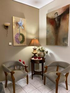 a living room with two chairs and a table with a lamp at top8 view in Tríkala