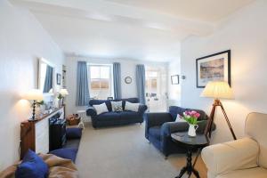 a living room with two blue chairs and a couch at Allonby Cottage in Kippford