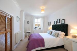 a bedroom with a large bed and a window at Allonby Cottage in Kippford