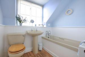 a bathroom with a toilet and a sink and a tub at Allonby Cottage in Kippford +26 photos