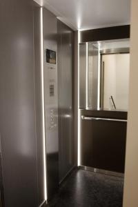 a bathroom with a mirror and a stainless steel door at Central Chic Antwerp 201 in Antwerp