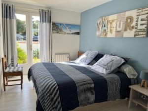 a bedroom with a bed with a blue wall at Les Floralies in La Tranche-sur-Mer