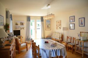 a living room with a table and chairs and a desk at Les Floralies in La Tranche-sur-Mer
