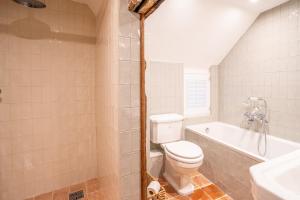 a bathroom with a toilet and a tub and a sink at Beautiful Cottage in Hatfield Broad Oak - Near Stansted Airport in Hatfield Broad Oak
