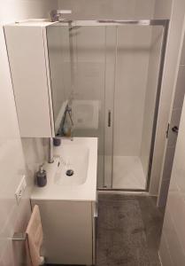 a white bathroom with a shower and a sink at Beachfront Arguinegin by Canary deluxe in Arguineguín