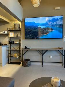 a living room with a large screen tv on a wall at Loft 181 by Oikies Rentals in Neoi Epivates