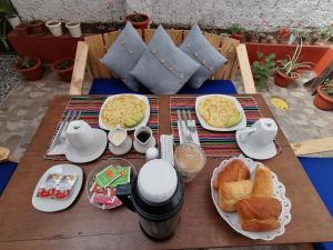 a wooden table with breakfast food on it at Magnolia Andina Hotel in Cusco