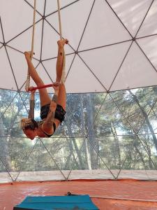 a woman on a rope swing in a tent at La Muntanera - Eco Yurt - Pool, Nature retreat in Figuerola