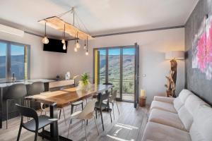 a kitchen and dining room with a table and a couch at Il nido tra gli ulivi in Lucinasco