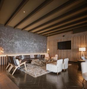 a living room with white furniture and a flat screen tv at The Mountains Hotel in Sierra Nevada