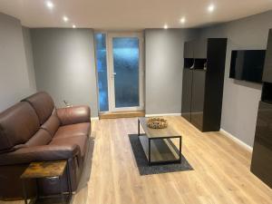 イーストボーンにあるBasement Flat in the town centre!の革張りのソファとコーヒーテーブルのあるリビングルーム