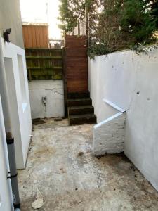 イーストボーンにあるBasement Flat in the town centre!の木塀のある家へと続く階段