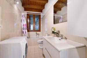a white bathroom with a sink and a washing machine at Lake and Love - Lago D'Iseo in Sulzano +18 photos