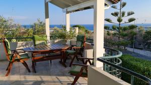 Un patio con una mesa y sillas en un balcón. en Casa Vacanza GLI ULIVI, en Santa Cesarea Terme