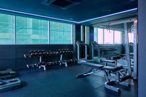 a gym with several tread machines and a mirror at Kin Hotel Thi Sach in Ho Chi Minh City +36 photos