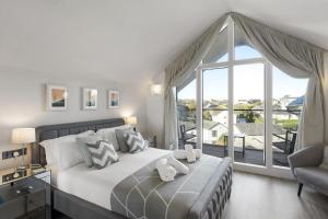 a bedroom with a large bed and a large window at Bright & Modern Townhouse Private Parking in Saint Columb Minor