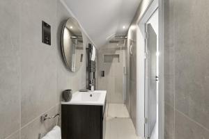 a bathroom with a sink and a shower with a mirror at Bright & Modern Townhouse Private Parking in Saint Columb Minor +28 photos