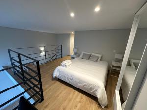 a bedroom with a white bed and a staircase at NEW Douro 901 Mezzanini with parking in Vila Nova de Gaia +7 photos