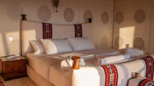 a bedroom with a bed with white sheets and pillows at Shiekh Horizon dunes in Al Raka
