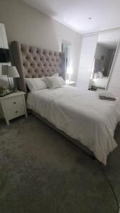 a bedroom with a large bed with a large headboard at 3 bedroom Sleeps 6 free parking in Glasgow