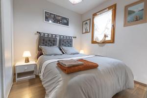 a white bedroom with a large bed and a window at Appartement Bois de Marie in Sers