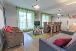 a living room with a couch and chairs and a table at Appartement Bois de Marie in Sers