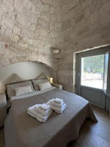 a bedroom with a bed with towels on it at Trullo Genesi in Cisternino