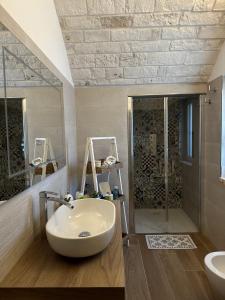 a bathroom with a white sink and a shower at Trullo Genesi in Cisternino +52 photos