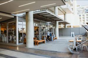 a building with people sitting at tables outside of it at Cosy one bedroom apartment in Windhoek