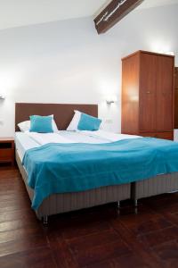 a large bed with blue sheets and a wooden cabinet at Casa Tisa in Băile Olăneşti +70 photos
