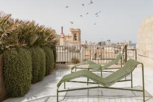 two green chairs sitting on top of a building at SCALA by Valletta Vintage in Valletta