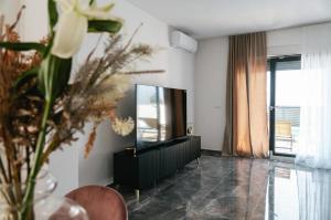 a living room with a television and a vase with flowers at Modern,Stylish Exclusive Villa with Pool&Jacuzzi in Rogoznica