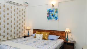 a bedroom with a bed with blue and gold pillows at Luho Ever shine in Bangalore