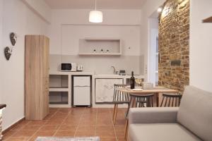 a kitchen and living room with a couch and a table at THIRAMNIA KaGa kythnosuites in Mérikhas