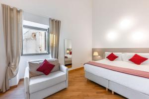 a bedroom with a bed and a couch and a window at Palazzo Indelli in Monopoli +37 photos