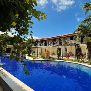 una grande piscina di fronte a un edificio di Bangalô 7 Carapibus a Conde