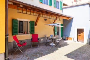 a patio with chairs and a table in front of a building at Appartamento Gloria in Cannobio