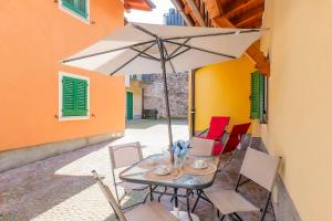 a table and chairs with an umbrella in a courtyard at Appartamento Gloria in Cannobio