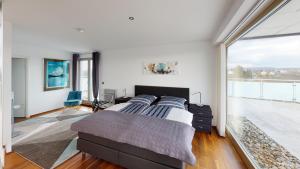 a bedroom with a bed and a large window at Penthouse für 2 Personen mit Dachterrasse und Rheinblick in Patersberg