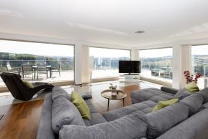 a living room with a large couch and a television at Penthouse für 2 Personen mit Dachterrasse und Rheinblick in Patersberg