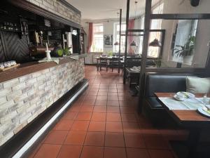 a restaurant with a brick wall and tables and chairs at Bierstadt-Hotel in Einbeck
