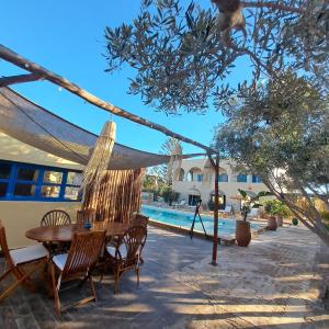 a patio with a hammock and a table and chairs at Villa 15 personnes avec piscine in Sidi Kaouki